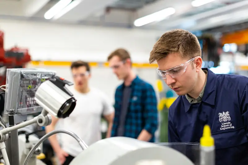 Engineers collaborating over drawings in a fabrication workshop