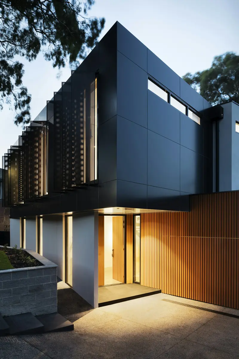 Modern home exterior with warm interior lighting at night