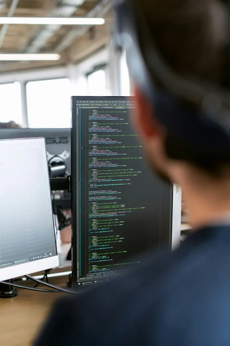 Estimator working through project plans at a dual-monitor workstation
