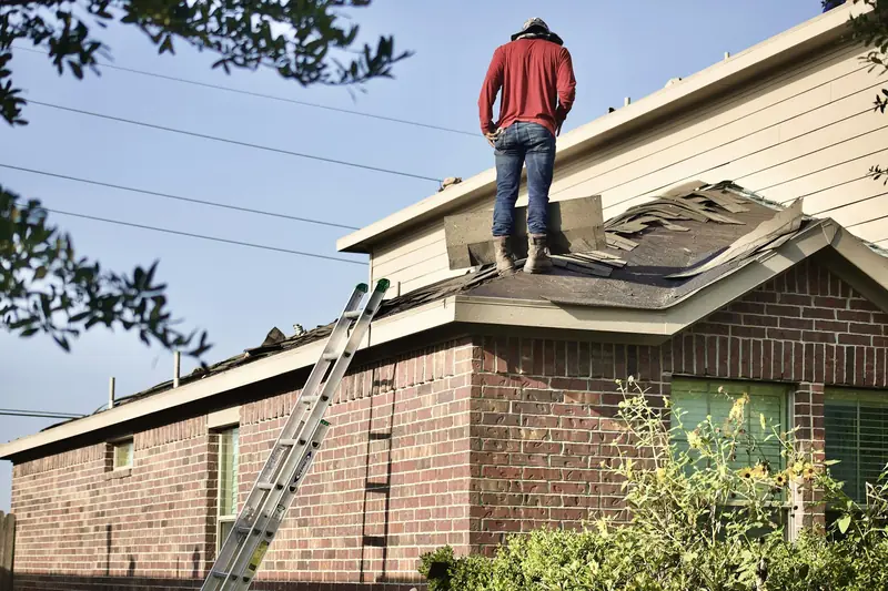 Roofer installing shingles on a residential roof