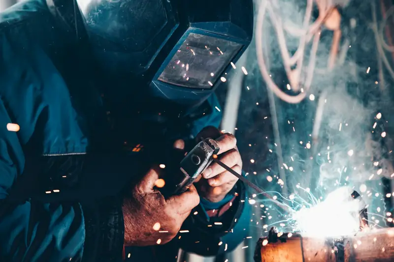 Welder joining structural steel with sparks flying